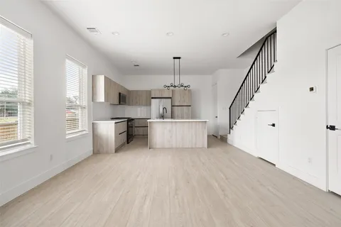 a view of a kitchen with furniture and wooden floor