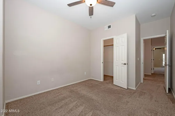 an empty room with chandelier fan
