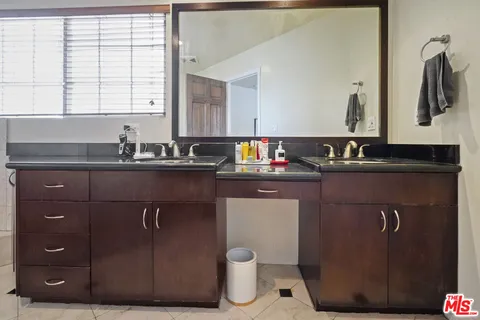 a bathroom with a granite countertop sink a toilet and mirror