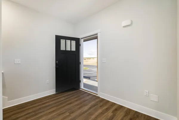 a kitchen with kitchen island granite countertop stainless steel appliances a refrigerator a sink a stove cabinets and wooden floor