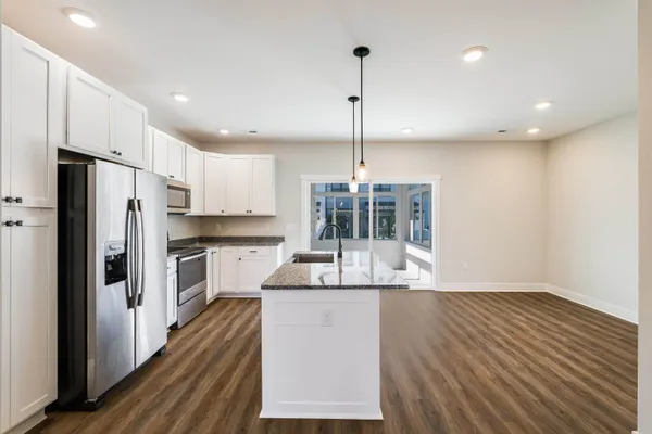a kitchen with kitchen island a counter top space appliances and cabinets