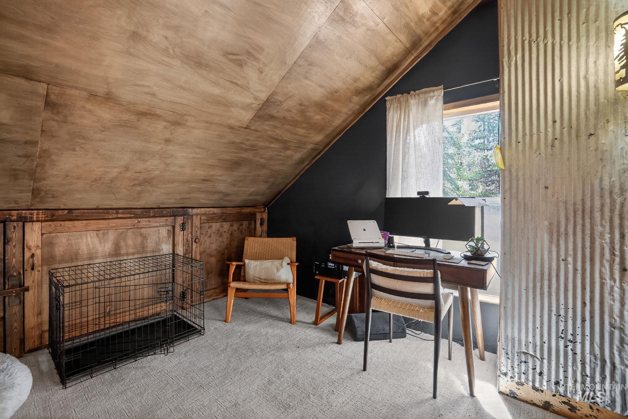 321 Secesh River Road McCall, ID 83638 - Photo 13 of 50 Attic space featuring sloped wood-finish paneling, a dark accent wall, and a window with natural light