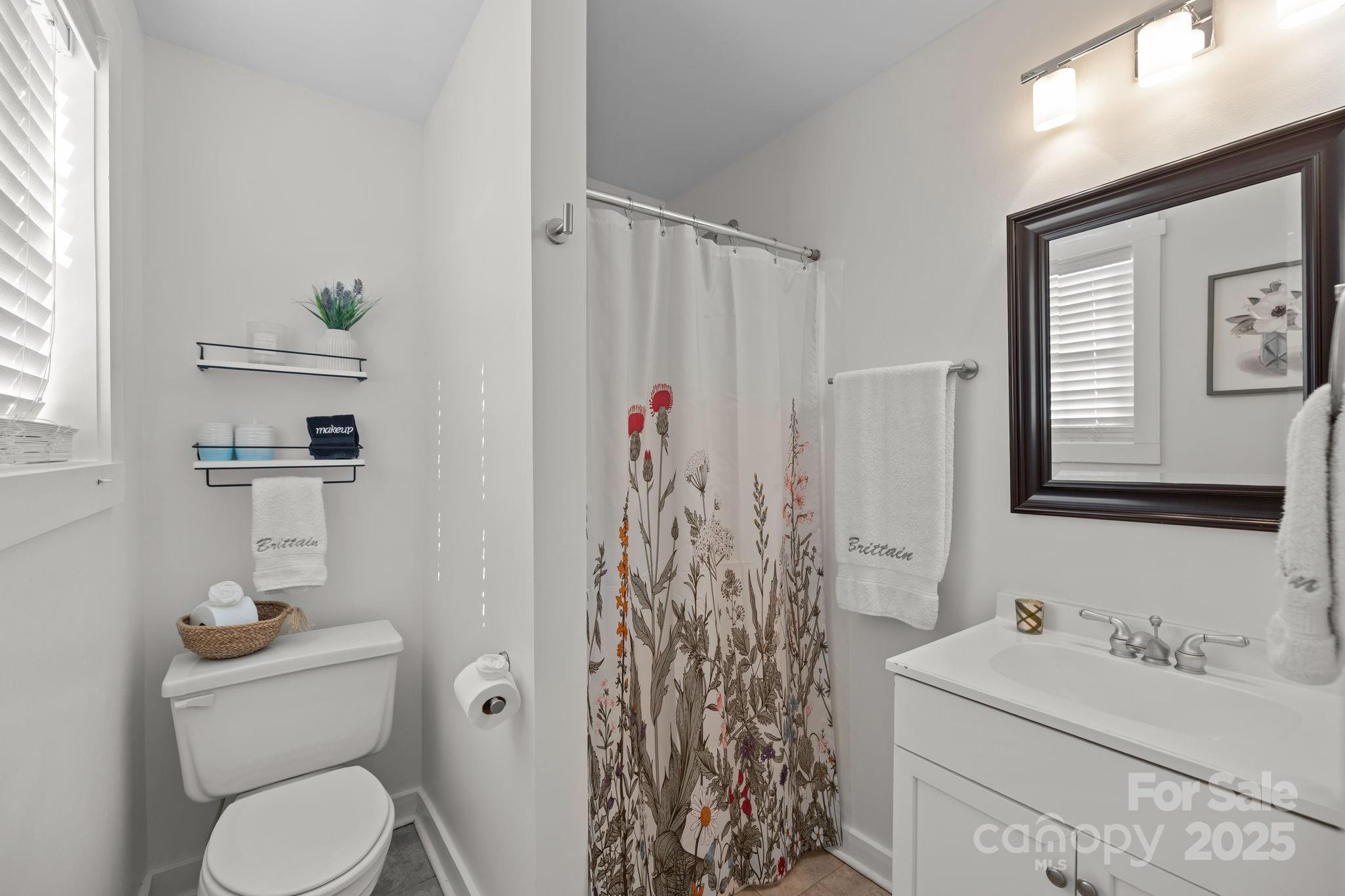 5509 Southampton Road Charlotte, NC 28217 - Photo 23 of 35 a bathroom with a toilet sink and shower curtain
