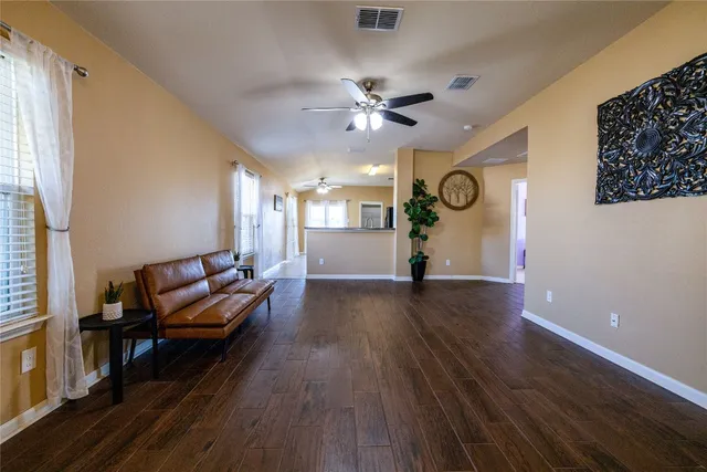 a living room with furniture and wooden floor
