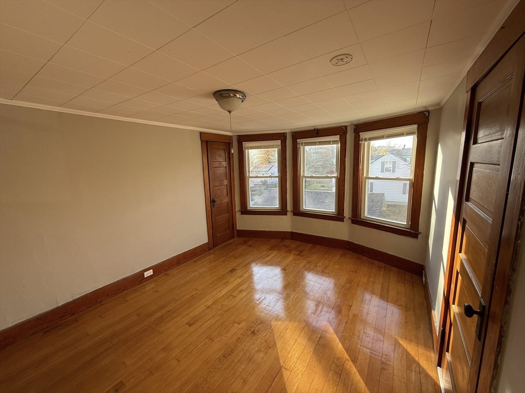 306 Franklin Road, Unit 2 Fitchburg, MA 01420 - Photo 8 of 17 a view of an empty room with a window and wooden floor