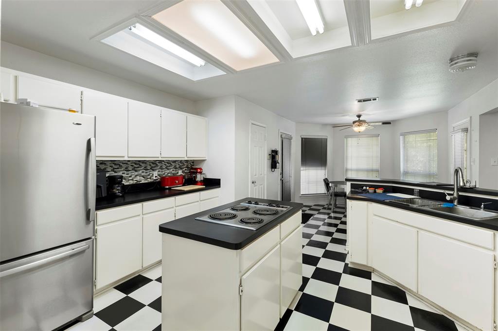 401 Rugged Drive Red Oak, TX 75154 - Photo 18 of 40 Kitchen featuring black and white checkerboard flooring, white cabinetry, black countertops, and a mosaic tile backsplash