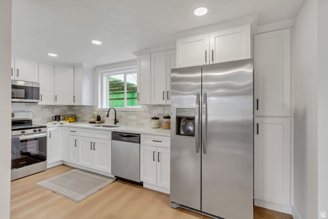 337 West 2900th Street South Bountiful, UT 84010 - Photo 7 of 35 Kitchen featuring stainless steel appliances, white cabinetry, backsplash, light wood-style floors, and recessed lighting