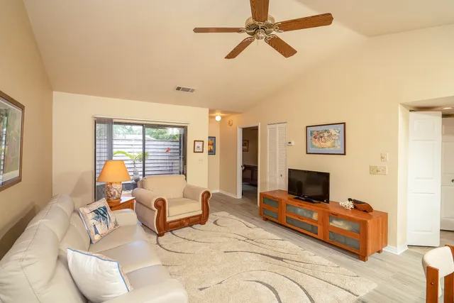 a kitchen with stainless steel appliances granite countertop a refrigerator a stove a sink and white cabinets with wooden floor