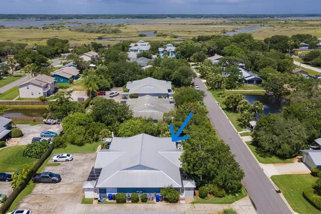 an aerial view of residential houses with outdoor space and trees