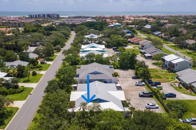 a view of a house with a yard and potted plants