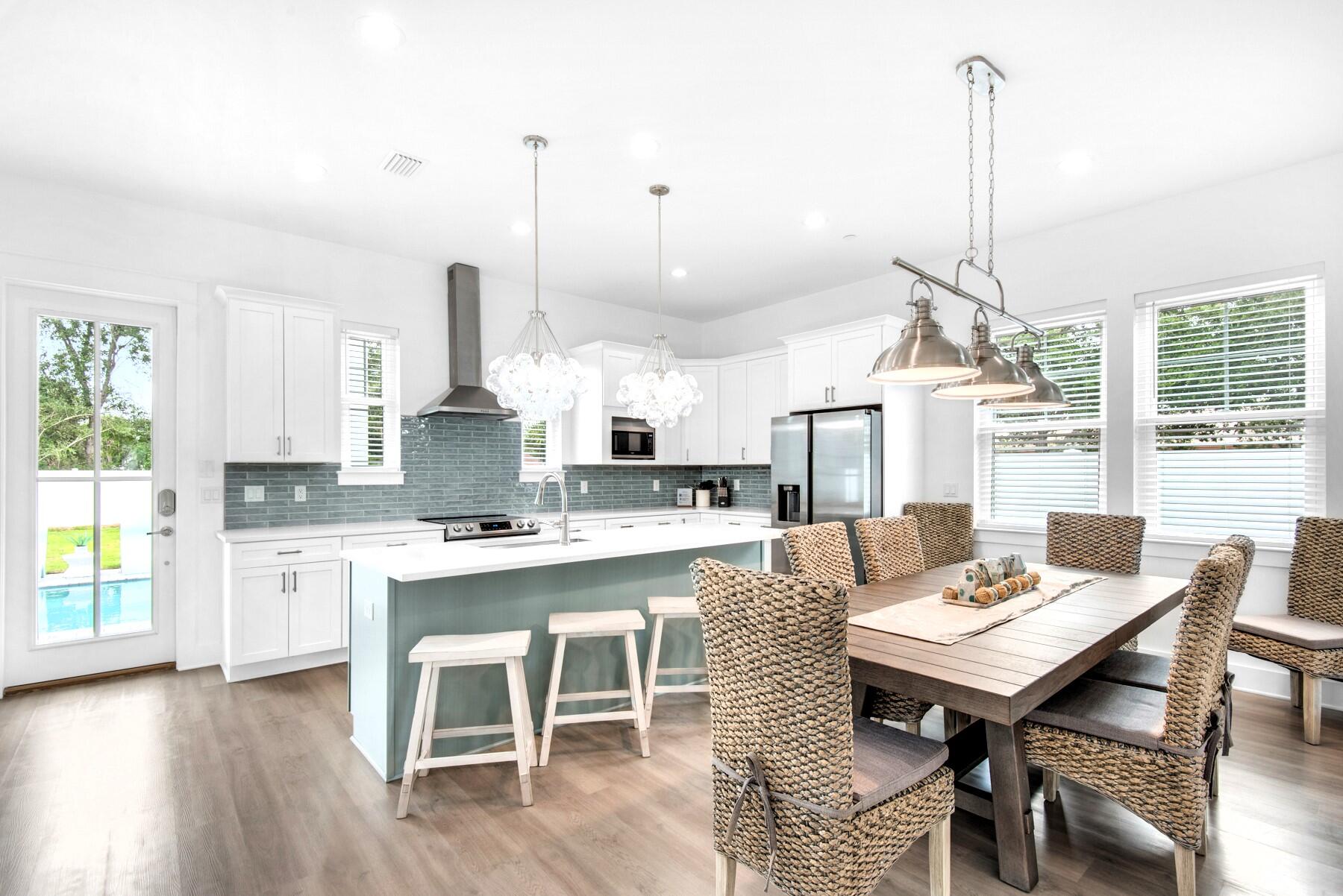 4543 Luke Avenue Destin, FL 32541 - Photo 12 of 45 a open kitchen with stainless steel appliances kitchen island granite countertop a table chairs and a wooden floor