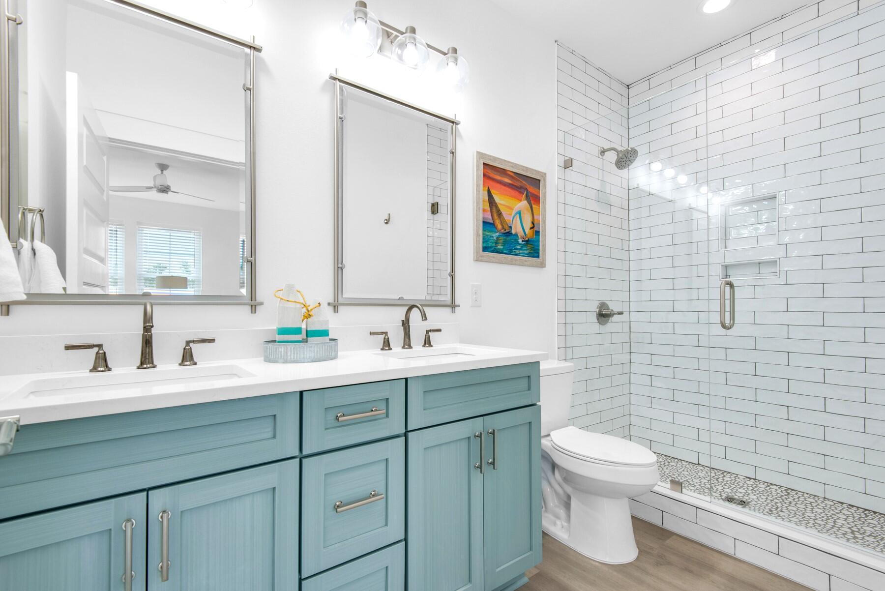 4543 Luke Avenue Destin, FL 32541 - Photo 44 of 45 a bathroom with a toilet sink a mirror and shower