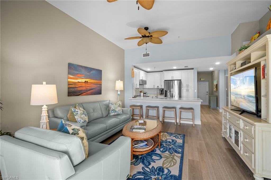 4455 Botanical Pl Circle, Unit 405 Naples, FL 34112 - Photo 16 of 46 a living room with furniture and a flat screen tv