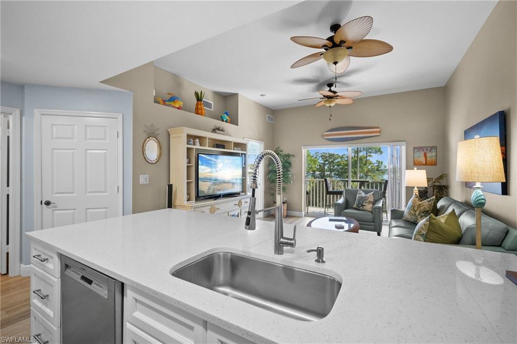 4455 Botanical Pl Circle, Unit 405 Naples, FL 34112 - Photo 17 of 46 a kitchen with a sink appliances and a chandelier