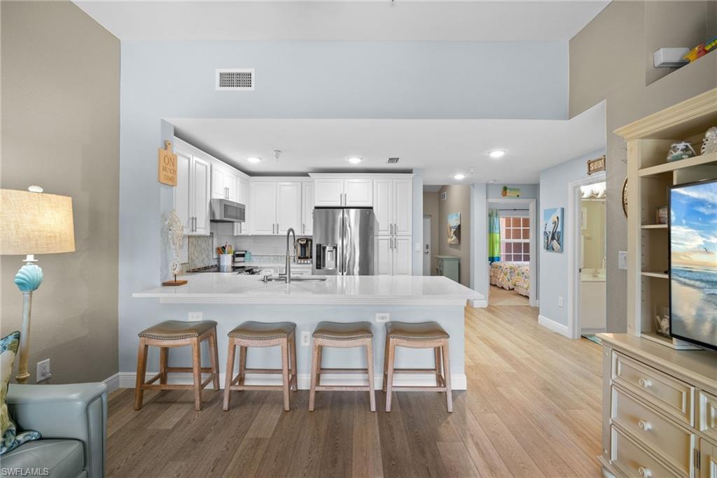 4455 Botanical Pl Circle, Unit 405 Naples, FL 34112 - Photo 18 of 46 a large kitchen with a table and chairs