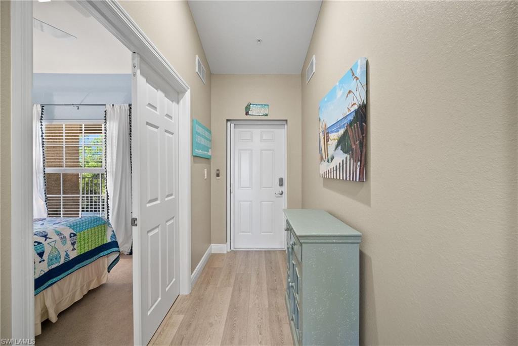4455 Botanical Pl Circle, Unit 405 Naples, FL 34112 - Photo 19 of 46 a view of a hallway with wooden floor and windows