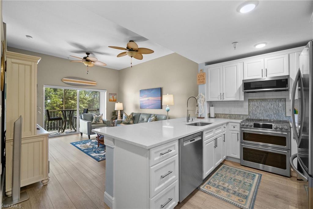 4455 Botanical Pl Circle, Unit 405 Naples, FL 34112 - Photo 2 of 46 a kitchen with a stove a sink and a refrigerator
