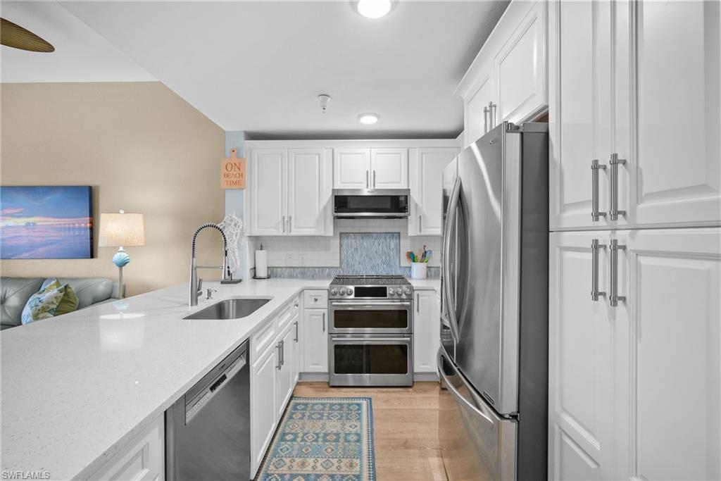 4455 Botanical Pl Circle, Unit 405 Naples, FL 34112 - Photo 21 of 46 a kitchen with a sink appliances and cabinets