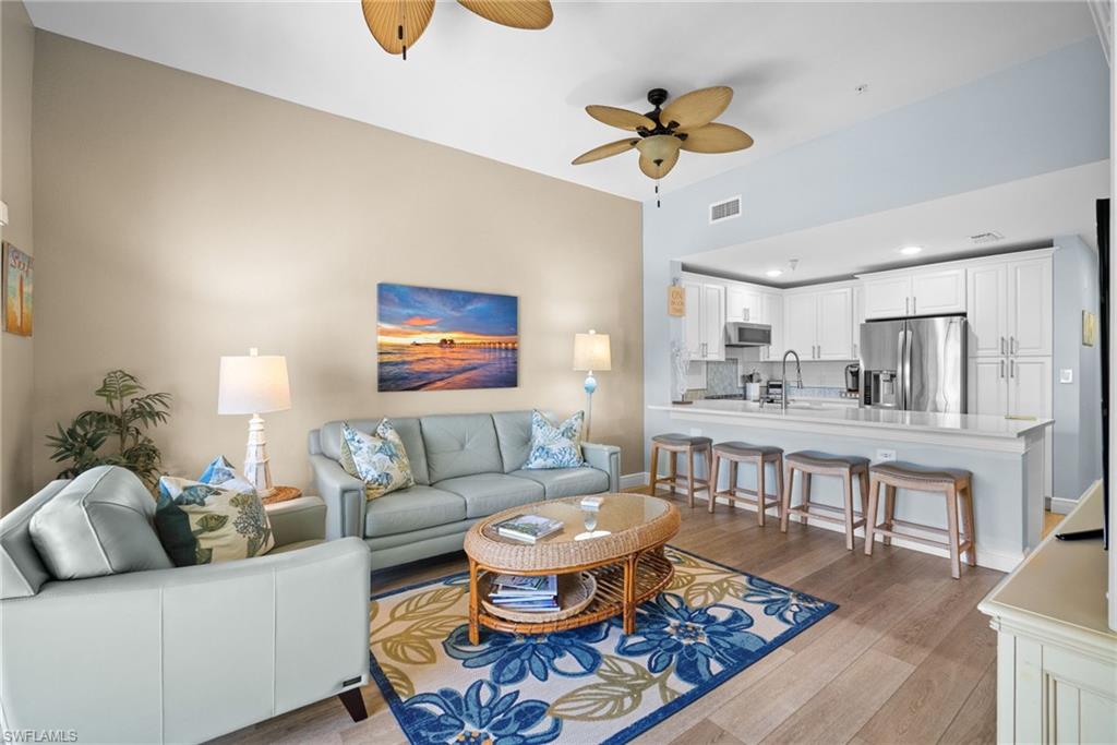 4455 Botanical Pl Circle, Unit 405 Naples, FL 34112 - Photo 22 of 46 a living room with furniture a rug and a chandelier