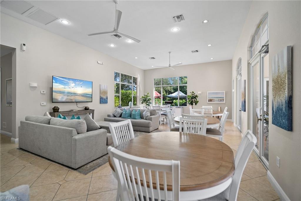 4455 Botanical Pl Circle, Unit 405 Naples, FL 34112 - Photo 31 of 46 a living room with furniture a large window and a flat screen tv