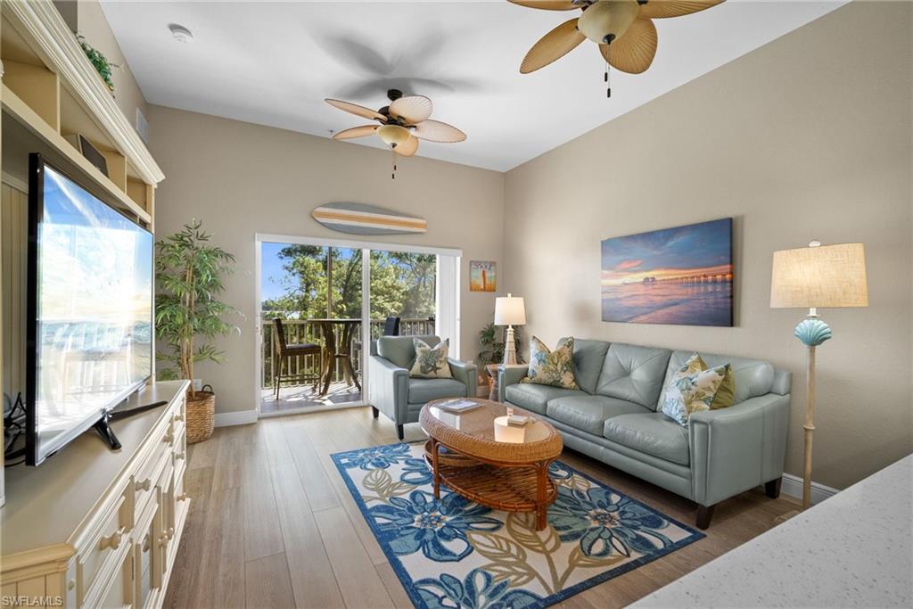4455 Botanical Pl Circle, Unit 405 Naples, FL 34112 - Photo 4 of 46 a living room with furniture and a large window
