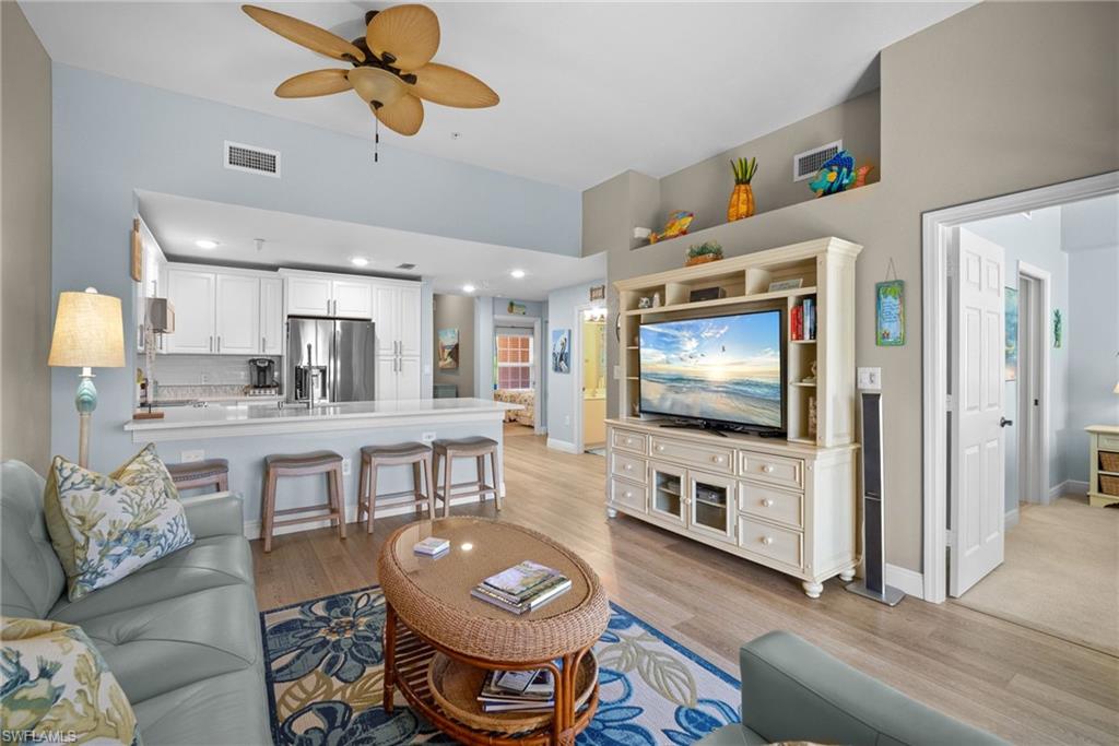 4455 Botanical Pl Circle, Unit 405 Naples, FL 34112 - Photo 6 of 46 a living room with furniture and a flat screen tv