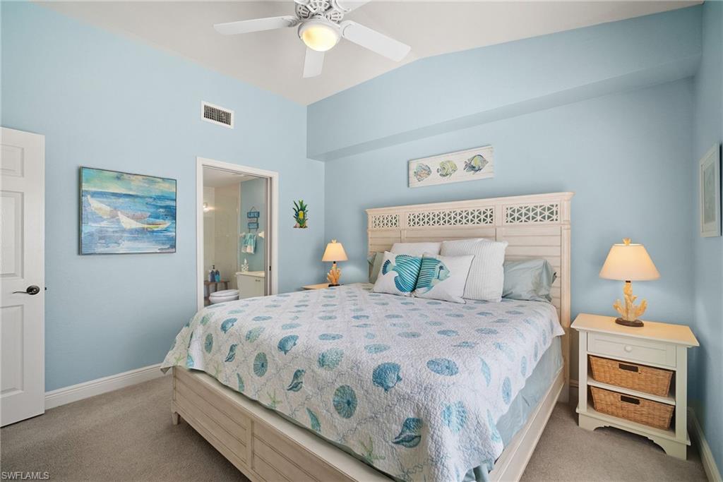 4455 Botanical Pl Circle, Unit 405 Naples, FL 34112 - Photo 9 of 46 a bedroom with a bed and a lamp on dresser