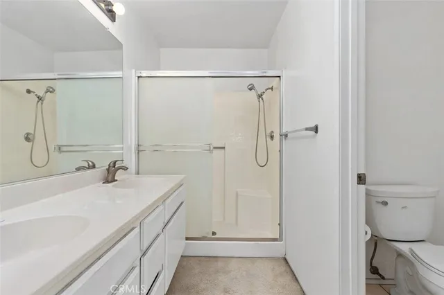 a bathroom with a sink toilet vanity and shower