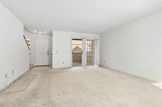 a view of an empty room with a kitchen