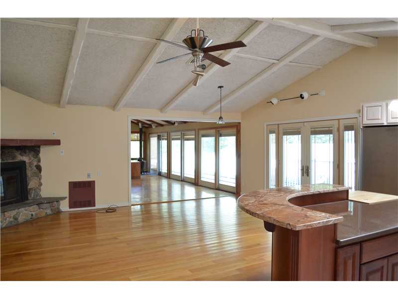 1700 Bulgarmarsh Road Tiverton, RI 02878 - Photo 3 of 12 Living Room. Living room w/ fireplace. Dining area. Den with wood stove. Patio doors to deck area.