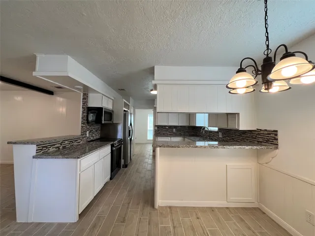 an empty room with wooden floor and white walls