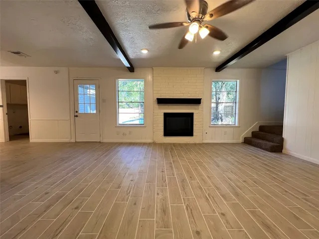 a large kitchen with granite countertop a stove top oven a sink and white cabinets
