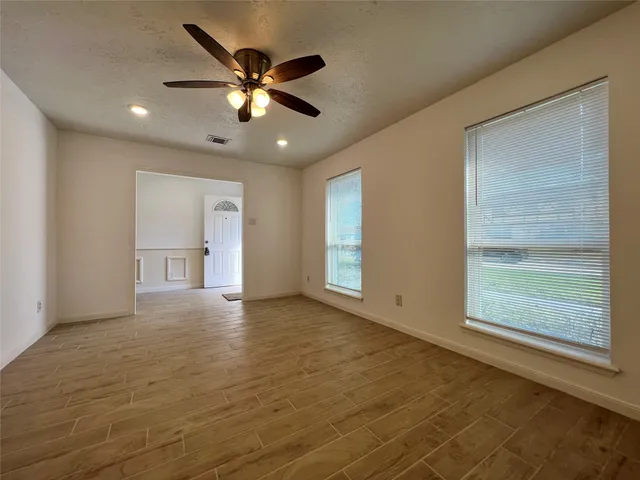 a view of an empty room with a fireplace and a window