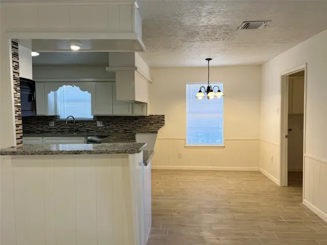 a kitchen with stainless steel appliances granite countertop a refrigerator a stove a sink and a microwave