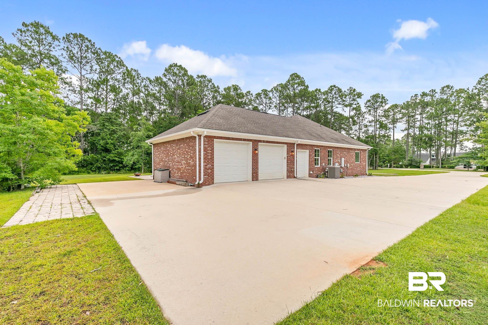 8145 Bay View Drive Foley, AL 36535 - Photo 58 of 81 View of property exterior with concrete driveway, a lawn, and brick siding