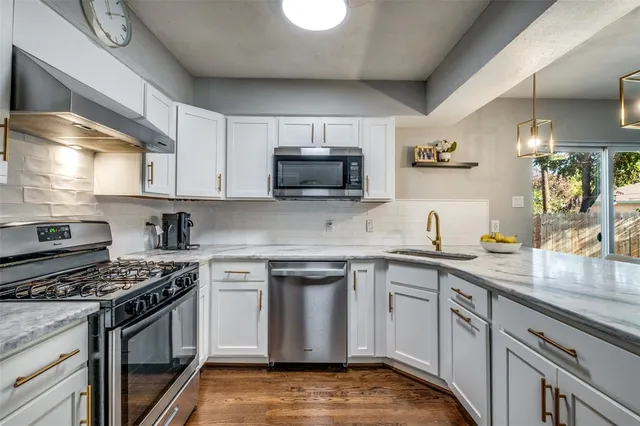 a kitchen with stainless steel appliances a stove sink and cabinets