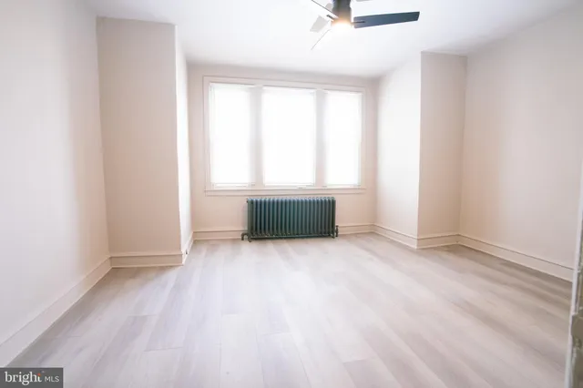 an empty room with a fireplace and windows