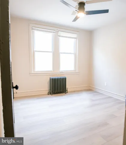 an empty room with a window and ceiling fan