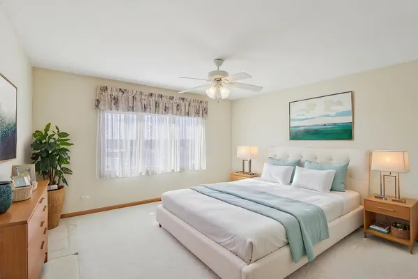 an empty room with a chandelier fan and windows
