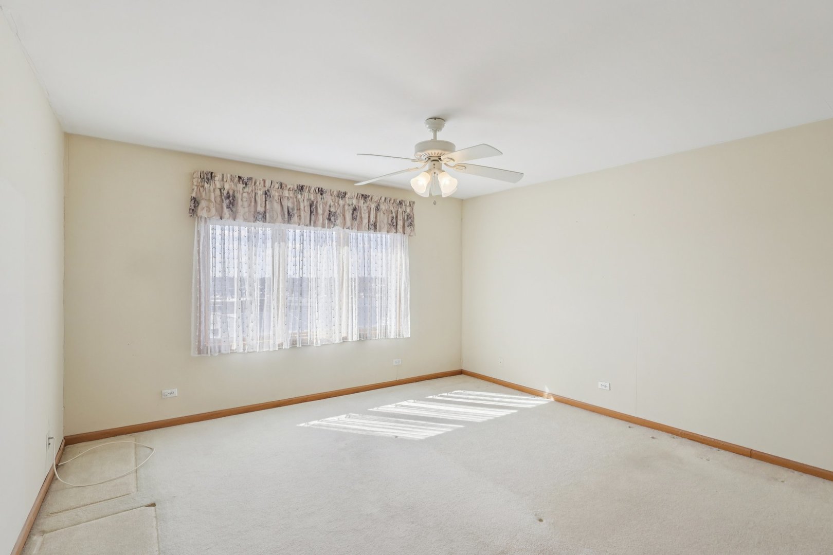7450 North Waukegan Road, Unit 505 Niles, IL 60714 - Photo 17 of 30 an empty room with a chandelier fan and windows