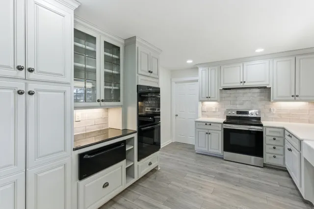 a view of a room with wooden floor ceiling fan and windows