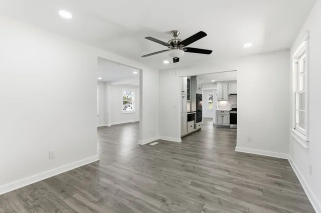 a view of empty room with wooden floor and window