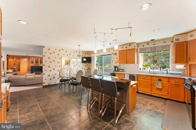 a view of a kitchen with kitchen island granite countertop a large counter top space and stainless steel appliances