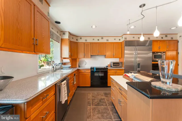 a kitchen with stainless steel appliances granite countertop a sink and a stove