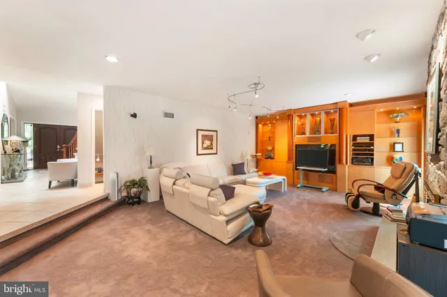a living room with furniture a flat screen tv and a large window