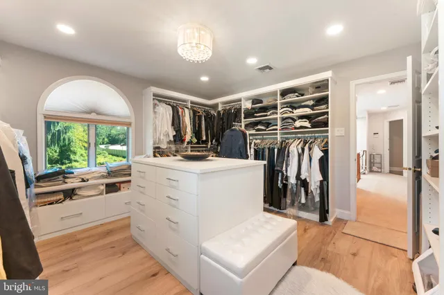 a view of walk in closet with clothes and shoes