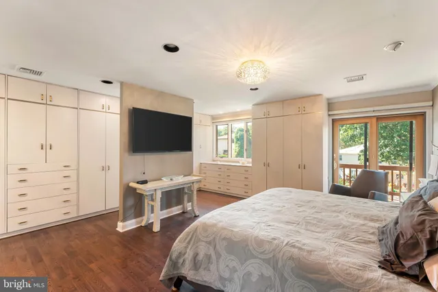 a bedroom with a bed and a flat tv screen on wall