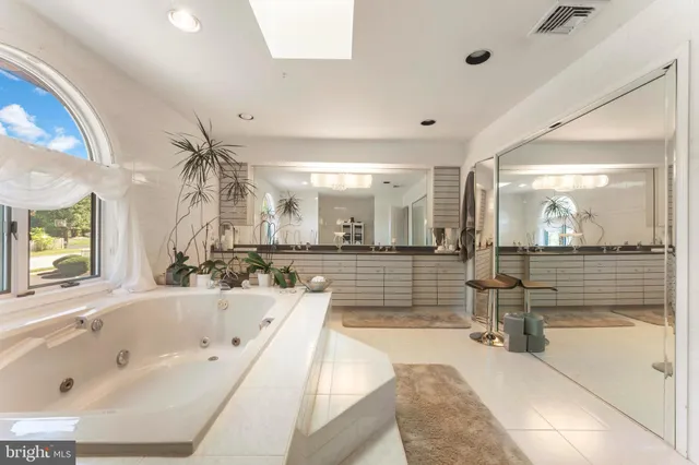 a spacious bathroom with a sink a large mirror and a shower