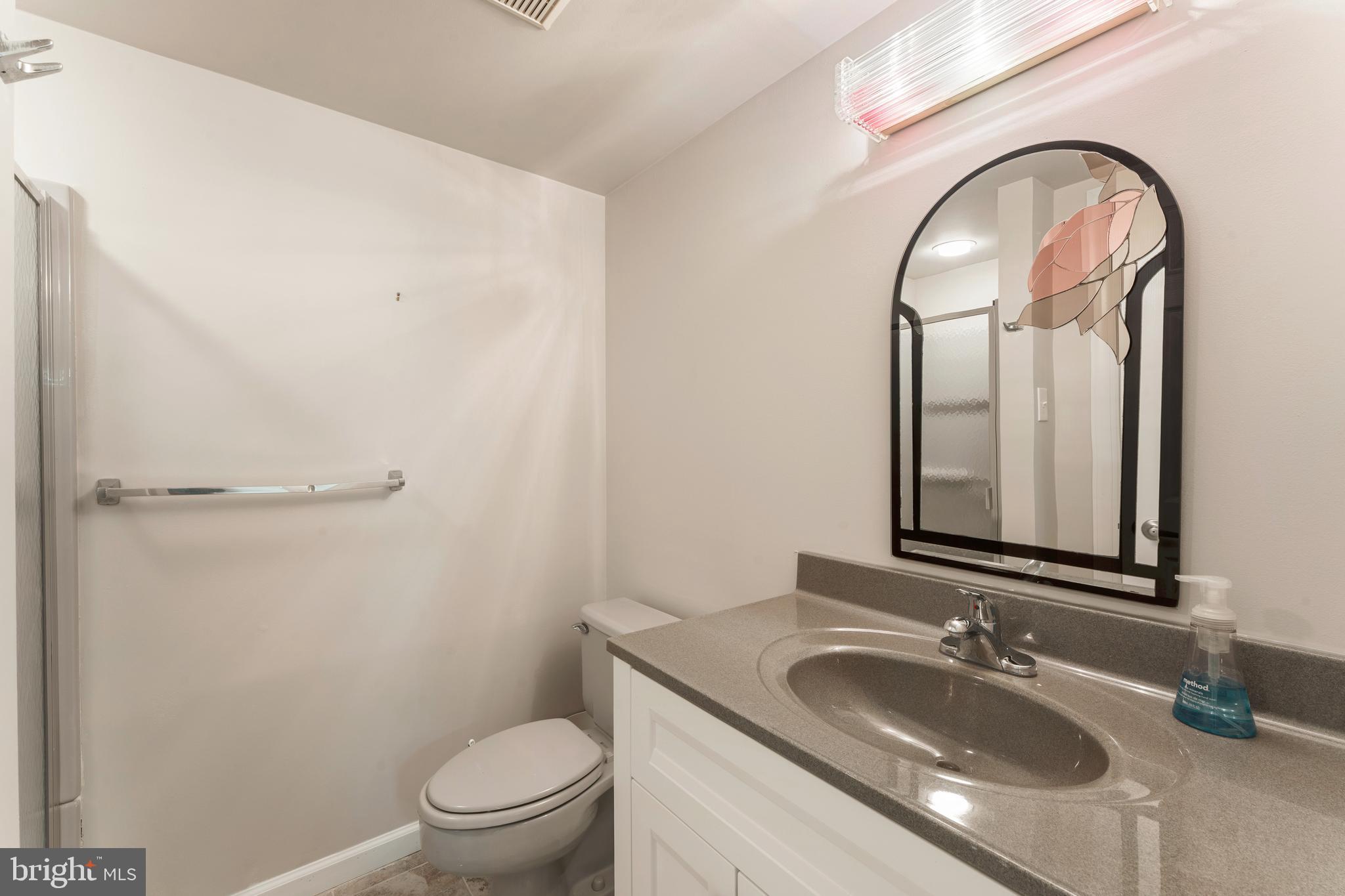 3843 Loop Road Huntingdon Valley, PA 19006 - Photo 47 of 51 a bathroom with a granite countertop toilet a sink and a mirror