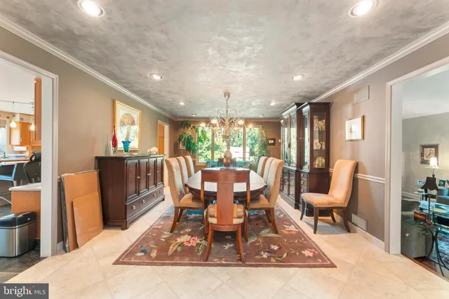 a dining room with furniture a chandelier and wooden floor